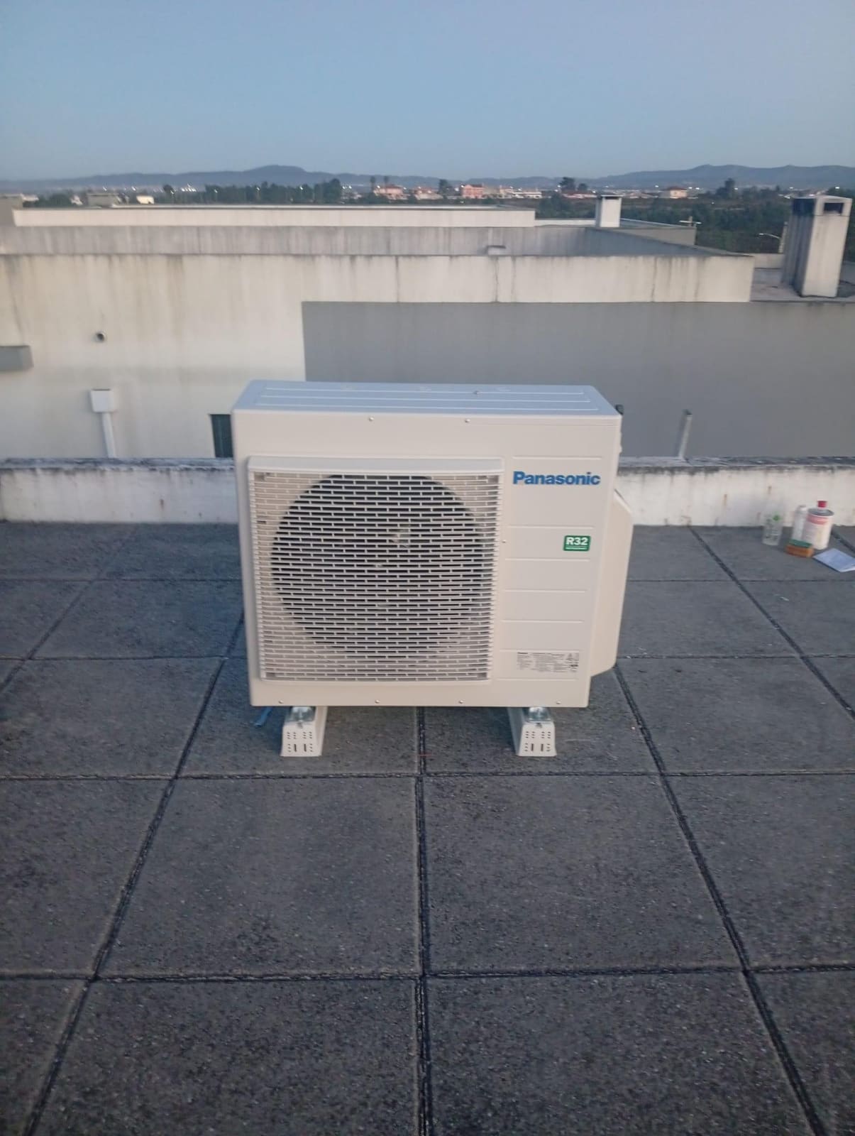 Unidade exterior de ar condicionado Panasonic num terraço